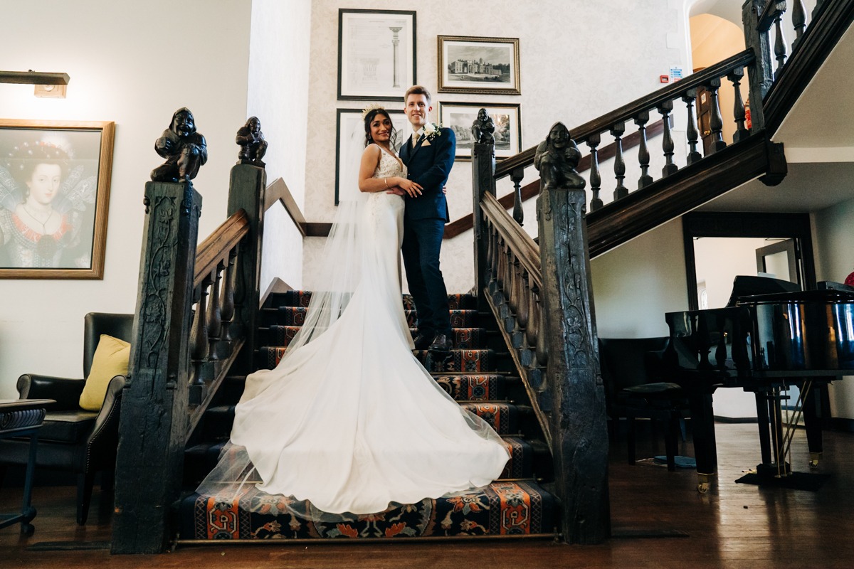 bride and groom at Eastwell Manor staircase wedding kent